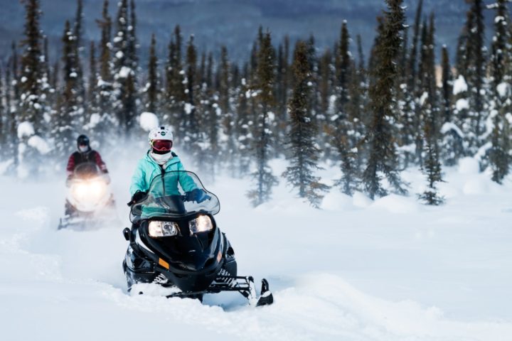 a man riding a motorcycle down a snow covered slope
