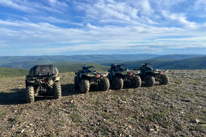 Four ATVs parked on a rocky hilltop overlooking the vastness of the White Mountains National Recreation Area.